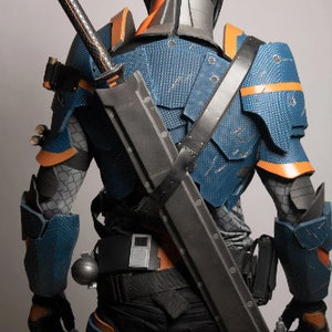May include: A blue and orange armoured costume with a black sword strapped to the back. The costume has a helmet with a blue visor.