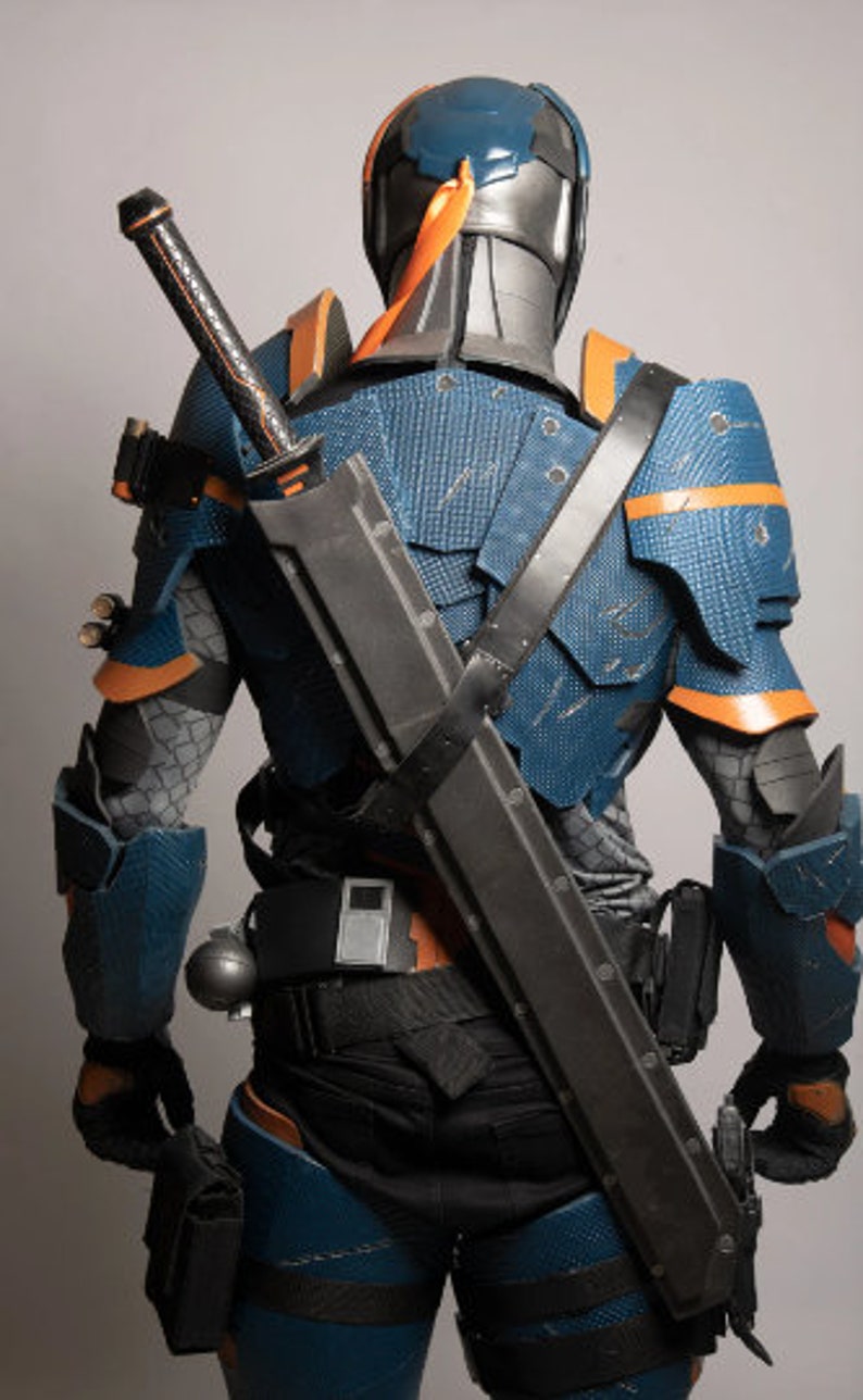 May include: A blue and orange armoured costume with a black sword strapped to the back. The costume has a helmet with a blue visor.
