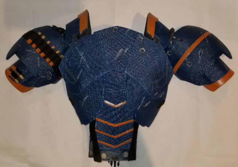 May include: Blue and orange costume armour piece with a textured fabric surface.