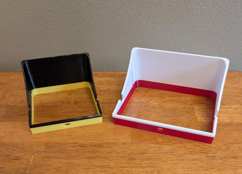 Here is a side by side comparison of the two sizes of the GoPro sunshade.  On the left in black and yellow for this example, is the standard sized shade.  On the right in white and red is the media sized shade.  You can see that the media sized shade is wider and taller to accommodate easy setup with the popular Media mod.
