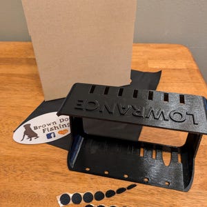 May include: A black 3D printed Lowrance fish finder mount with a cardboard box, black adhesive backing, and black hook and loop fasteners.