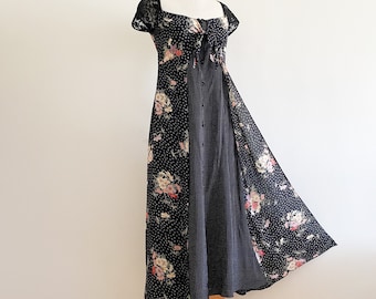 May include: A black maxi dress with a floral print and a lace trim on the sleeves. The dress has a tie at the neckline and a flowing skirt.