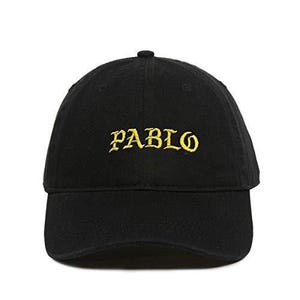 Puede incluir: Gorra de b&eacute;isbol negra con la palabra "PABLO" bordada en hilo dorado en la parte delantera. La gorra tiene una visera curva y un peque&ntilde;o bot&oacute;n en la parte superior.