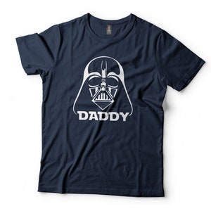 May include: A navy blue t-shirt with a white graphic of Darth Vader's helmet and the word "DADDY" underneath.