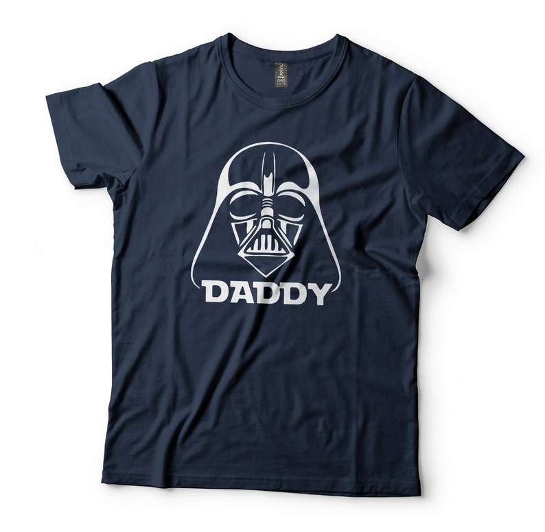 May include: A navy blue t-shirt with a white graphic of Darth Vader's helmet and the word "DADDY" underneath.