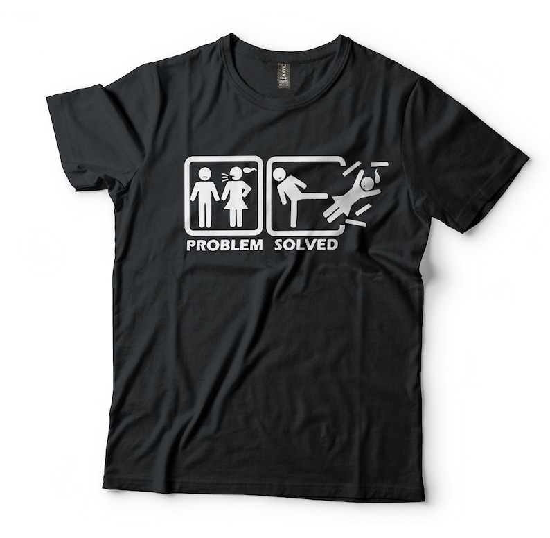 Puede incluir: Camiseta negra con un gr&aacute;fico blanco de dos figuras de palo. La primera figura de palo muestra a una mujer grit&aacute;ndole a un hombre. La segunda figura de palo muestra al hombre pateando a la mujer. El texto "PROBLEM SOLVED" est&aacute; debajo del gr&aacute;fico.