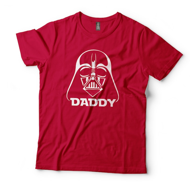 May include: Red t-shirt with a white graphic of Darth Vader's face and the word "DADDY" underneath.