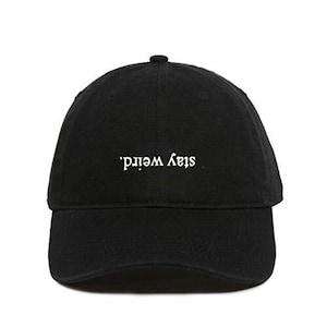 May include: Black baseball cap with white embroidered text that reads 'Stay Weird'.