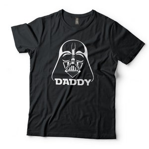 May include: Black t-shirt with a white graphic of Darth Vader's helmet and the word "DADDY" underneath.