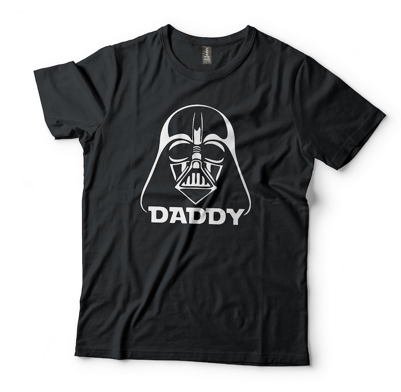 May include: Black t-shirt with a white graphic of Darth Vader's helmet and the word "DADDY" underneath.