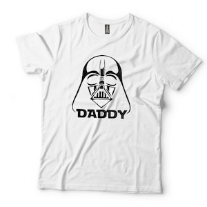 May include: White t-shirt with a black and white illustration of Darth Vader's face and the word "DADDY" underneath.