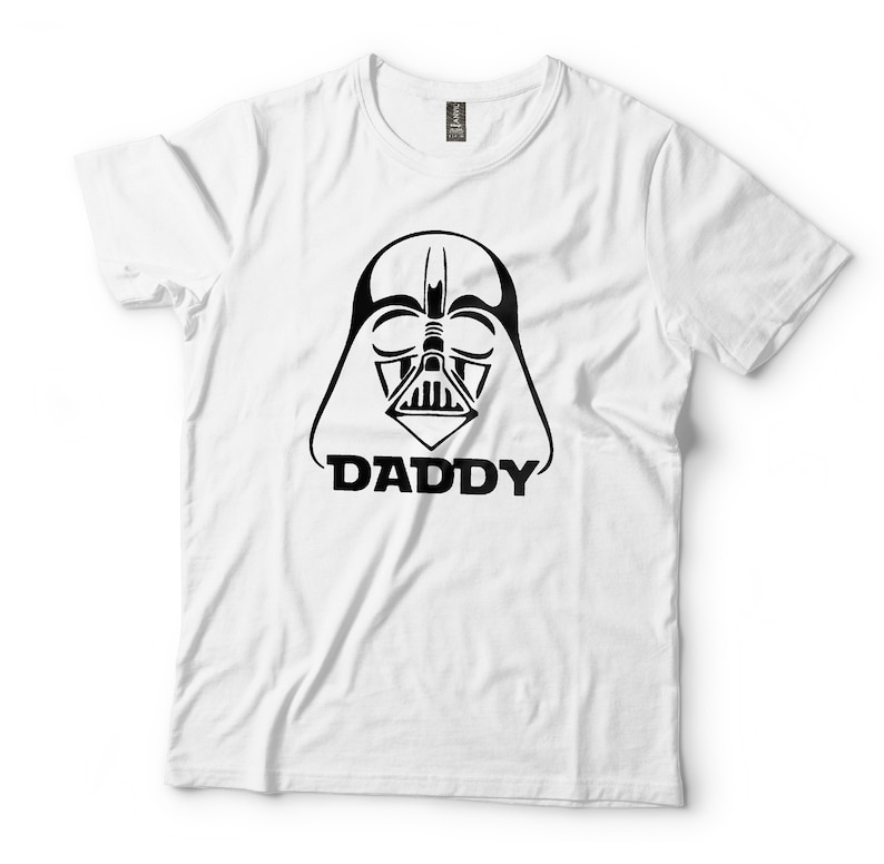 May include: White t-shirt with a black and white illustration of Darth Vader's face and the word "DADDY" underneath.