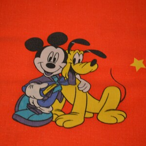 Könnte beinhalten: Ein roter Hintergrund mit einem Cartoon-Bild von Mickey Mouse und Pluto. Mickey Mouse trägt ein blaues und violettes Outfit und hält Plutos Pfote. Pluto ist ein gelber Hund mit schwarzen Ohren und einem schwarzen Schwanz.