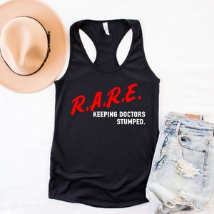 May include: Black tank top with the text "R.A.R.E. KEEPING DOCTORS STUMPED." in red and white lettering.