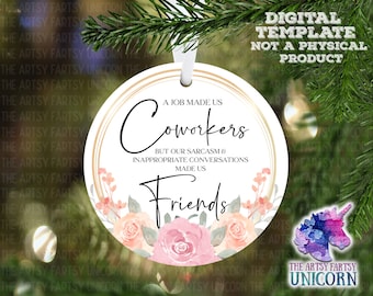 Op de afbeelding: Een ronde witte kerstbal met een gouden rand en een bloemenmotief. De kerstbal heeft de tekst "A job made us coworkers but our sarcasm & inappropriate conversations made us friends".