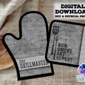 May include: A gray and white oven mitt with the text "The Grillmaster" on it. A smaller gray and white square with the text "Rub Smoke Eat Repeat" is also included.