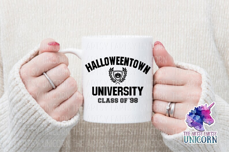 May include: White ceramic mug with a black graphic that says "Halloweentown University Class of '98". The graphic includes a black and white illustration of a pumpkin with a wreath around it.