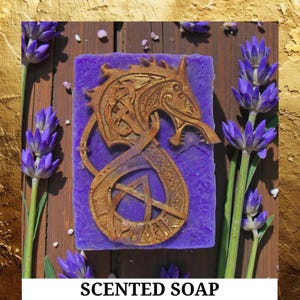 May include: A purple scented soap bar with a gold dragon design. The soap is surrounded by lavender sprigs on a wooden surface. The text "SCENTED SOAP" is at the bottom of the image.