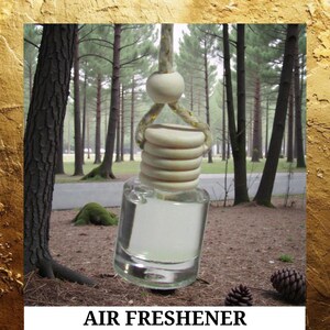 May include: Clear glass air freshener bottle with a wooden top and a hanging rope. The bottle is filled with a clear liquid. The text "AIR FRESHENER" is displayed at the bottom of the image.