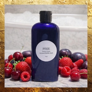 May include: A dark blue bottle of "Pixie Sweet Fruits Scented Bubble Bath" with a black cap. The bottle is surrounded by fresh cherries, raspberries, and plums. The label indicates the bottle contains 4 oz of product.
