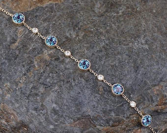 May include: A delicate gold chain bracelet with alternating blue and clear round gemstones. The bracelet has a simple design and is perfect for everyday wear.
