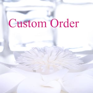 May include: White paper flower with a center that resembles a fluffy pom-pom. The text "Custom Order" is written in pink above the flower.
