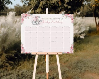 May include: A light pink baby shower calendar on a wooden easel. The calendar features the text "GUESS THE ARRIVAL OF Baby Ashley" and a floral and elephant design. The calendar includes a calendar grid for September and October.