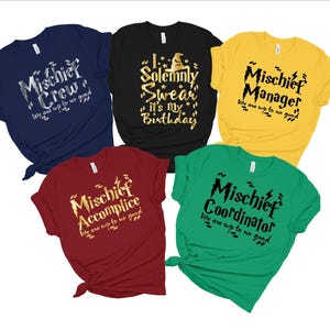 May include: Five t-shirts with a Harry Potter theme. The shirts are in different colors and feature gold lettering with a lightning bolt graphic. The text on the shirts reads "Mischief Crew", "Mischief Accomplice", "Solemnly Swear It's My Birthday", "Mischief Manager", and "Mischief Coordinator".