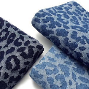May include: Three pieces of fabric with a leopard print pattern. The fabric is a dark blue denim with a lighter blue leopard print.