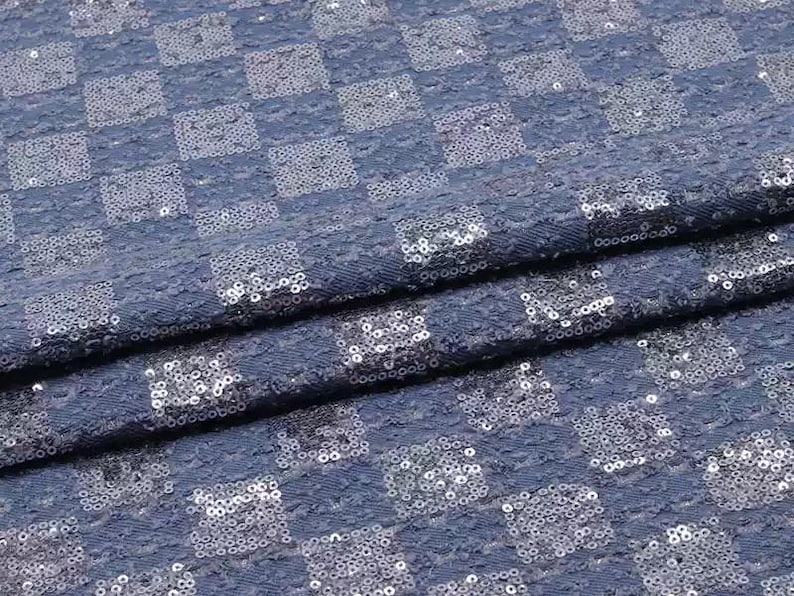 May include: Blue fabric with a checkered pattern made of silver sequins.