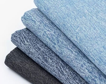 Op de afbeelding: Een stapel van vier denim stoffen in verschillende tinten blauw, met een donkergrijze stof aan de onderkant.