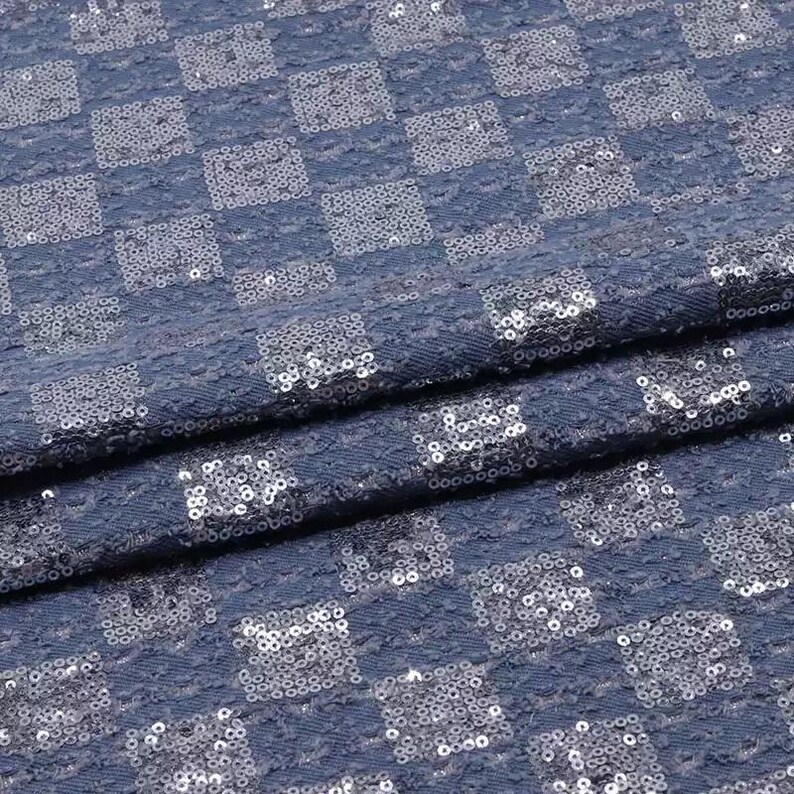 May include: Blue fabric with a checkered pattern made of silver sequins.