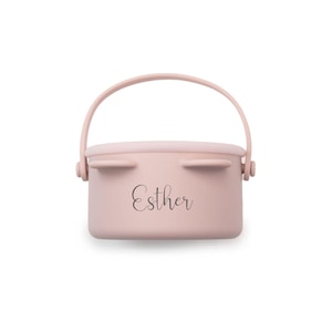 May include: A light pink, rectangular container with a curved handle. The container has a lid with two small, ear-like protrusions. The name "Esther" is written in cursive on the front.
