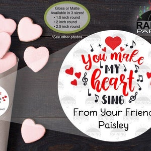 May include: Round sticker with the text "You make my heart sing" in red and black lettering with musical notes and hearts. The sticker also includes the text "From Your Friend Paisley".