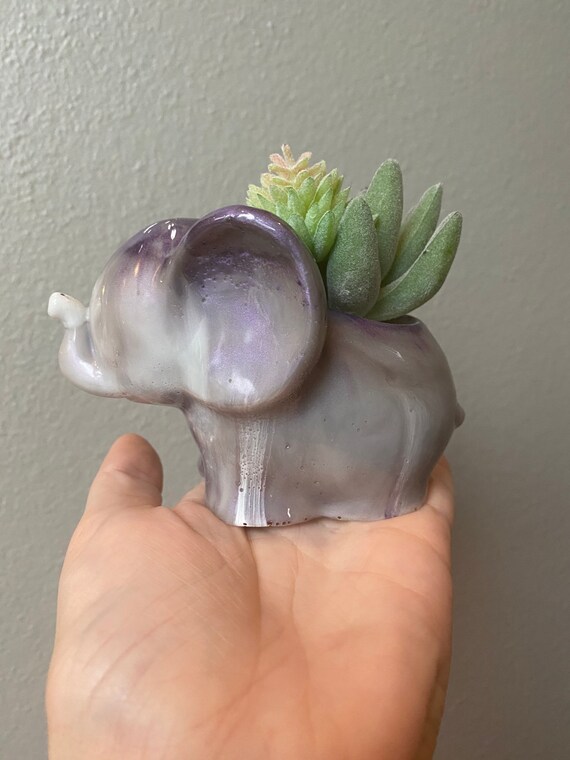 Adorable elephant succulent planter made of cast white and amethyst purple resin with faux pair of succulents and white small rocks