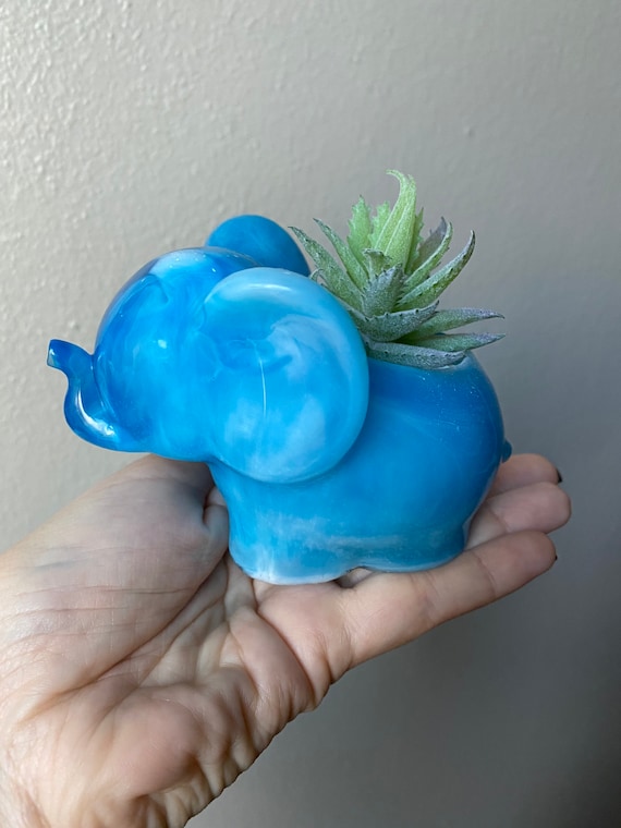 Adorable elephant succulent planter made of cast white and ultramarine blue resin with faux pair of succulents and white small rocks