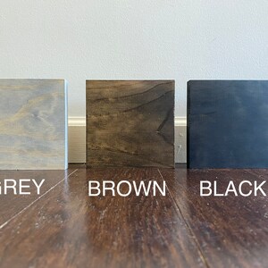 May include: Three wood samples, one grey, one brown, and one black.