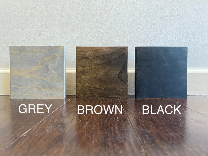 Puede incluir: Tres muestras de madera, una gris, una marr&oacute;n y una negra.