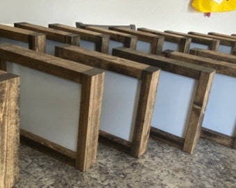 May include: A row of rustic wooden picture frames with a light gray background. The frames are all the same size and are arranged in a staggered pattern.