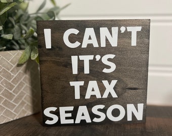 May include: A dark brown wooden sign with white text that reads "I can't it's tax season".