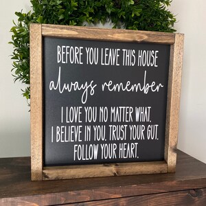May include: A wooden framed sign with a black background and white text that reads "Before you leave this house always remember I love you no matter what. I believe in you. Trust your gut. Follow your heart."