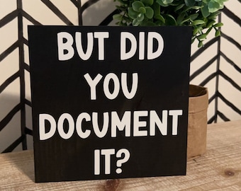 May include: Black wooden sign with white text that reads "But did you document it?"