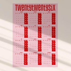 May include: A pink 2026 calendar with red text. The word "Twentytwentysix" is at the top. Each month is displayed in a grid format with the days of the week and dates. The calendar is a simple and modern design.