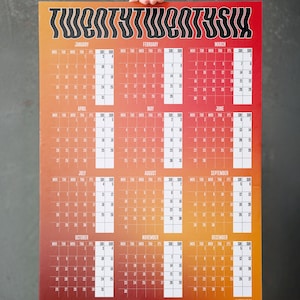 Puede incluir: Un calendario rectangular grande de 2026 con un fondo degradado de naranja a rojo. El calendario presenta los meses de enero a diciembre, con los días de cada mes claramente mostrados en casillas blancas. El título "TWENTYTWENTSIX" está en la parte superior.
