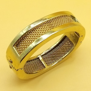 Pulsera rígida vintage de Ralph Lauren, gruesa, dorada, con bisagra y cierre magnético.