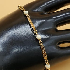 Vintage Avon dainty gold tone Asian style panel link bracelet with creamy bead accents