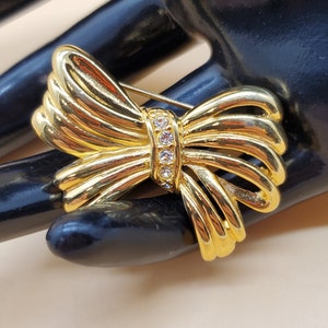 vintage gold tone bow pin brooch with clear rhinestone accents