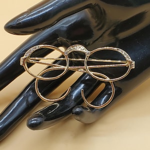 Vintage 1928 gold tone eyeglasses brooch with clear rhinestone accents