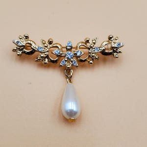 Vintage Art Nouveau style gold tone floral pin with dangling faux pearl