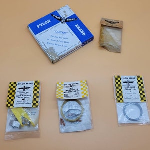 Peut inclure: Un ensemble de cinq pièces de modèle d'avion de la marque Pylon. Les pièces comprennent un clip de bougie d'allumage, un kit de fils de sortie et d'œillets en nylon, un fil de plomb et une feuille de plastique transparente. L'emballage est jaune et noir avec le logo de la marque Pylon.